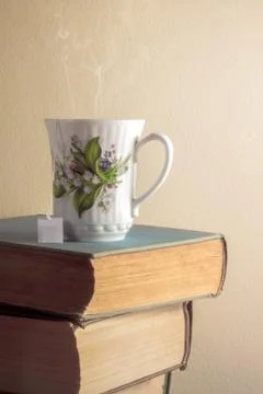 Cup of tea on stack of old books Stock Photos
