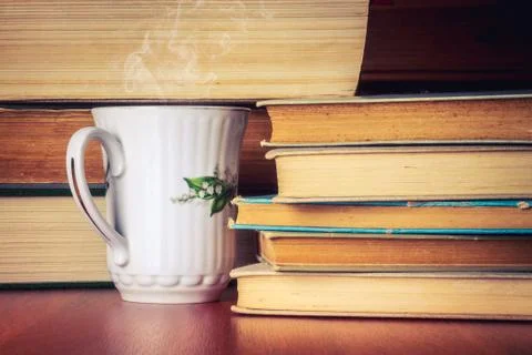 Cup of tea with stack of old books Stock Photos