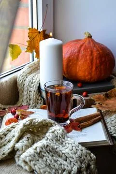 A cup of tea stands on books on the windowsill Fotos Stock