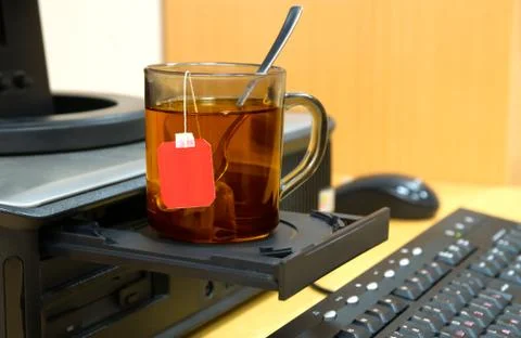 	The cup of tea stands on the disk drive of a computer Stock Photos