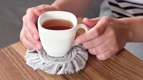 A cup of tea stands on a do-it-yourself knitted stand Stock Footage 244916592