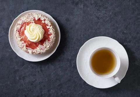 Cup of tea with strawberry cake top view on a dark background decorated Stock Photos