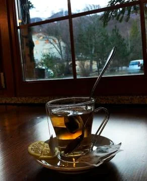 Cup of tea on table across mountains view and cafe window Stock Photos