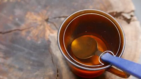 A cup of tea on the table. Close-up shot of a cup of tea with a spoon in it. Fotos de archivo