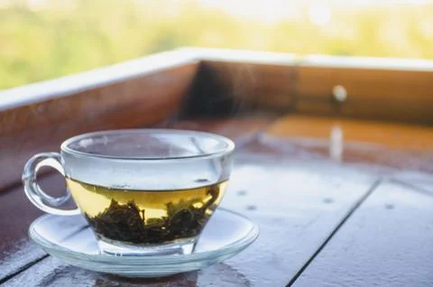 Cup with tea on table over mountains landscape with sunlight. Beauty nature b Stock Photos
