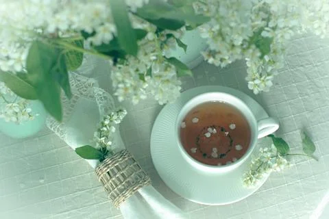 Cup of tea on the table with spring fresh bouquet with white blooming fragr.. Stock Photos