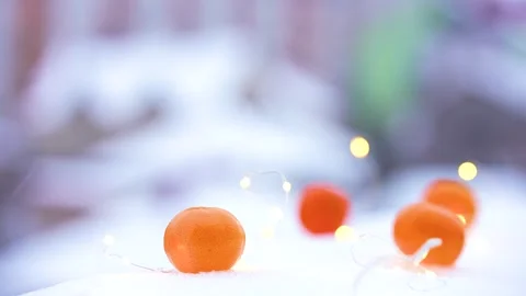 Cup of tea, tangerines in the snow and a garland. Stock Footage 257353353