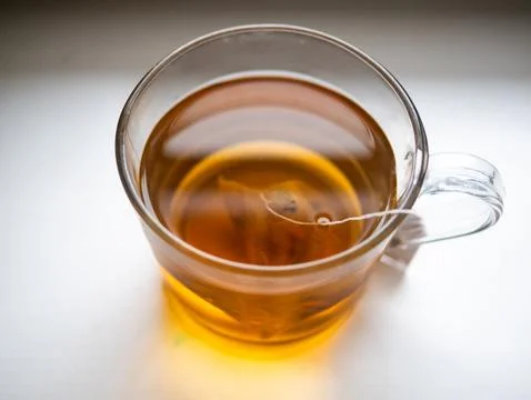A cup of tea with a tea bag in it Stock Photos