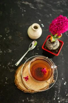 A cup of tea in a transparent cup with spring hyacinth flower on a black back Foto stock