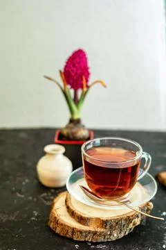 A cup of tea in a transparent cup with spring hyacinth flower on a black Stock Photos