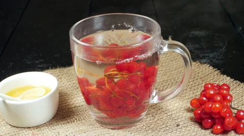 A cup of tea with viburnum on the table. Hot steam. Stock Footage 57777776