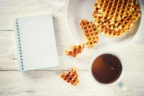 Cup of tea, waffle and notepad. Copyspace Stock Photos