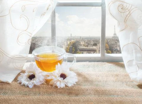 A cup of tea on the window in Paris with Eiffel Tower on the background. Stock Photos