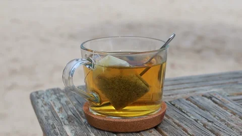 A cup of tea on wooden table on beach Stock Footage 107187038