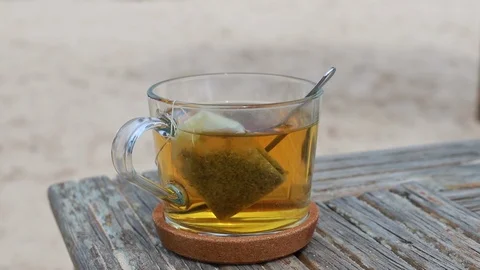 A cup of tea on wooden table on beach Video stock 107187527