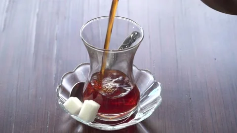In a Cup of Turkish tea, put sugar and stir with a spoon. Stock Footage 132428337