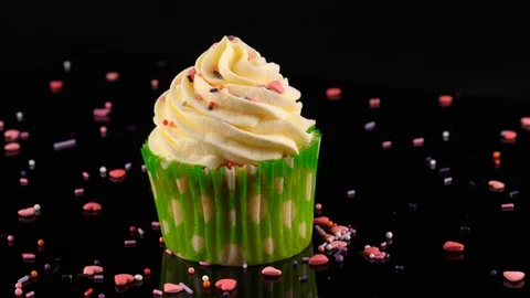 Cupcake, camera zoom in to close-up view, background decorated with sprinkles Stock Footage 91030020