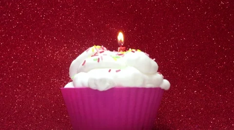 Cupcake with a candle on a bright red background Stock Footage 57055555
