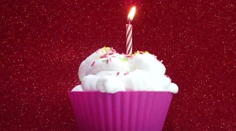 Cupcake with a candle on a bright red background Stock Footage 57055898