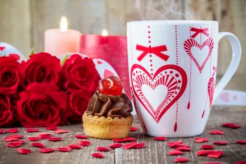 Cupcake with cherry in front of bouquet of red roses 스톡 사진