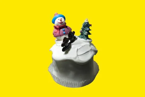 A cupcake decorated with a winter theme isolated on a yellow background Stock Photos