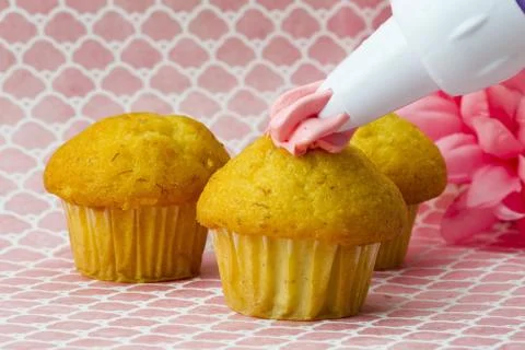 Cupcake decorating on a pink surface 스톡 사진