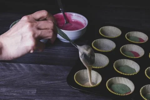 Cupcake dough is filled into the form. Stock Photos