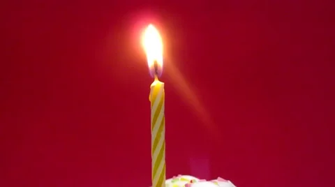 Cupcake with a lit candle over red background Stock Footage 54605642