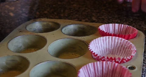 Cupcake paper cups being placed in cupcake pan close-up Video stock 208306580