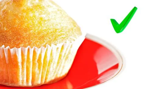 Cupcake on a plate, with a focus on the check mark. Stock-Fotos