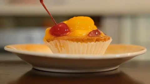 Cupcake with slice of orange and cherry on top Stock Footage 125705474