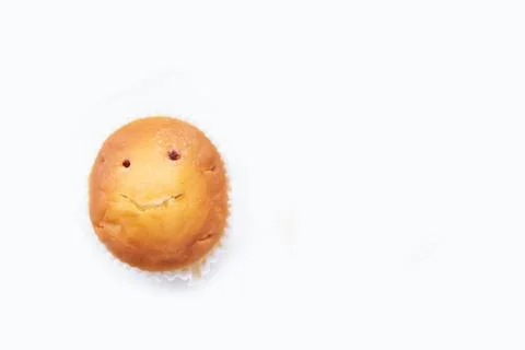 Cupcake with a smiling face on a white background. There is space for text. Stock Photos
