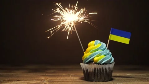 Cupcake with Ukrainian flag. Bengal fires or fireworks are burning in the cake Stock Footage 197366973