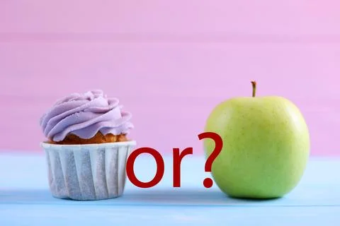 Cupcake versus Apple A Debate Between Sweet Indulgence or a Healthy Snack Choice Stock Photos