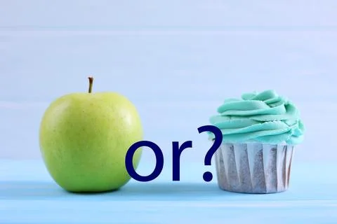 Cupcake versus Apple A Debate Between Sweet Indulgence or a Healthy Snack Choice Foto stock