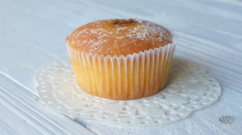 Cupcake on a white wooden table. Rotation. Video stock 58472000