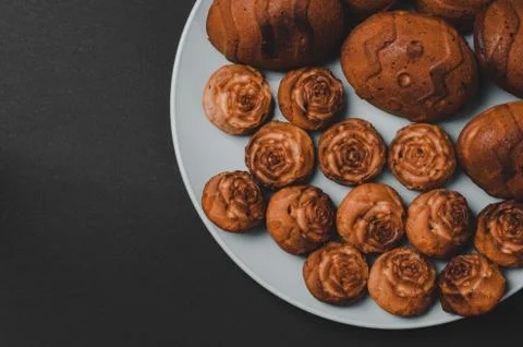 Cupcakes of different sizes on a black background with space for text. Stock Photos