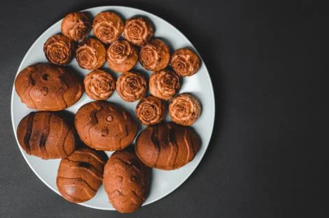 Cupcakes of different sizes on a black background with space for text. Stock Photos