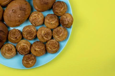 Cupcakes of different sizes on a yellow background close-up. Stock Photos