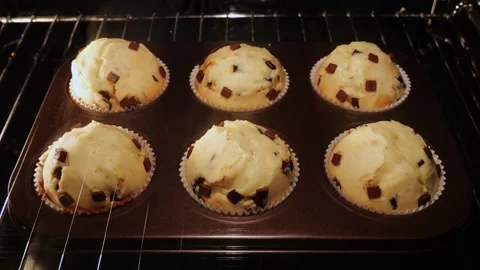 Cupcakes, muffins with chocolate chips baking tin in oven, time lapse, close up. Vídeos de archivo 253597212