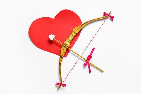 Cupid's bow and red paper heart on light background. Valentine's Day celebrat Stock Photos