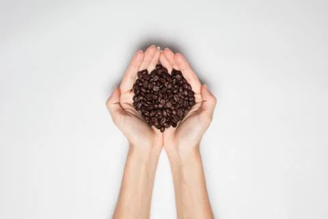 Cupped hands holding coffee beans Stock Photos