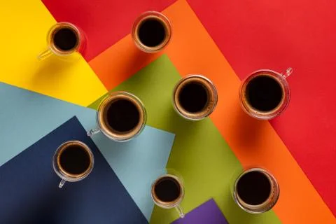 Cups with black coffee on rainbow background Stock Photos