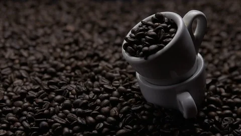 Cups of coffee with the beans falling into the background Stock Footage 120757713