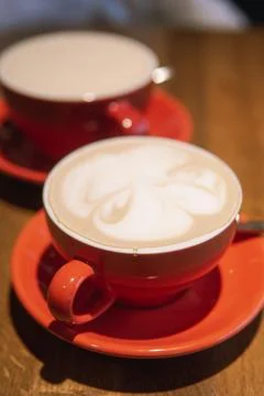 Cups of coffee in vibrant red ceramic mugs with intricate surface designs, Stock Photos