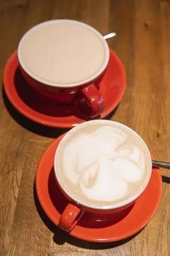 Cups of coffee in vibrant red ceramic mugs with intricate surface designs, Foto stock