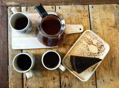 Cups of drip coffee, coffee jar and piece of chocolate cake Foto stock