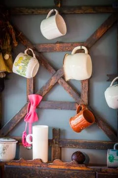 Cups hanging in a rustic kitchen Stock Photos