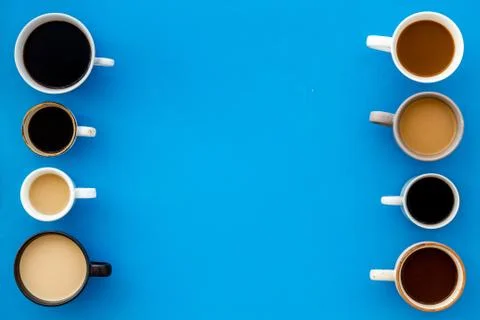 Cups of hot drinks on blue table top-down space for text Stock Photos