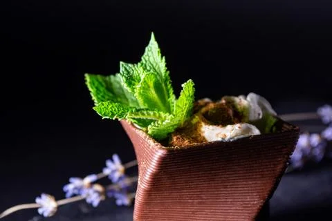 Cups printed on a 3D printer with chocolate, whipped cream and mint leaves 写真素材